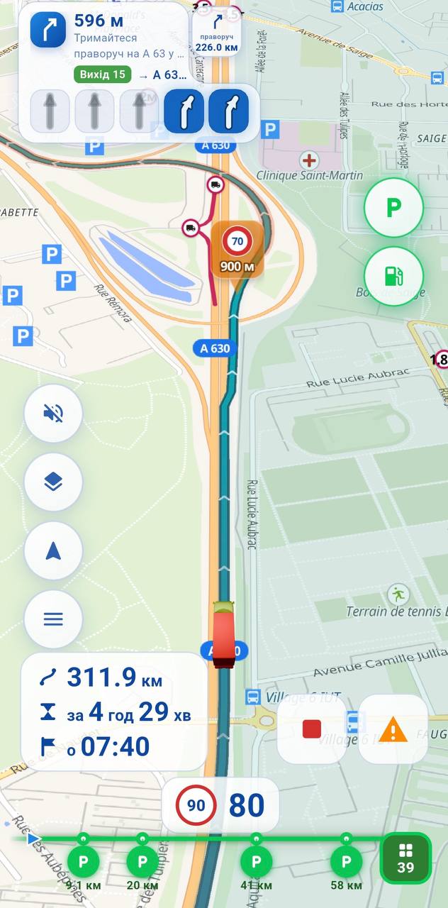 Екран навігації NavTiro: з'їзд 15 на A 63 за 596 метрів, панель смуг, обмеження 70 через 900 метрів, 311,9 км за 4 години 29 хвилин